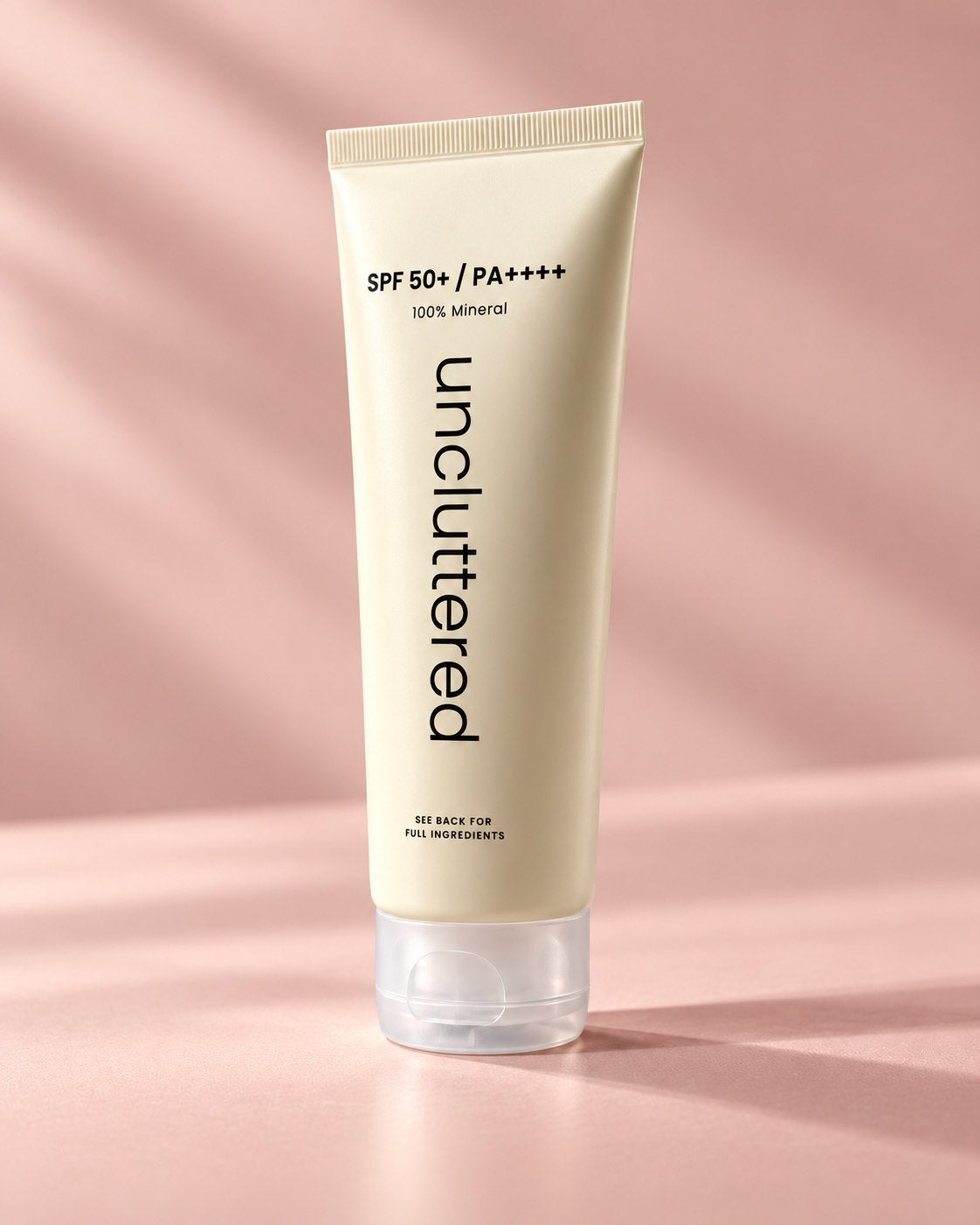 Uncluttered mineral sunscreen sealed tube angled against blush background