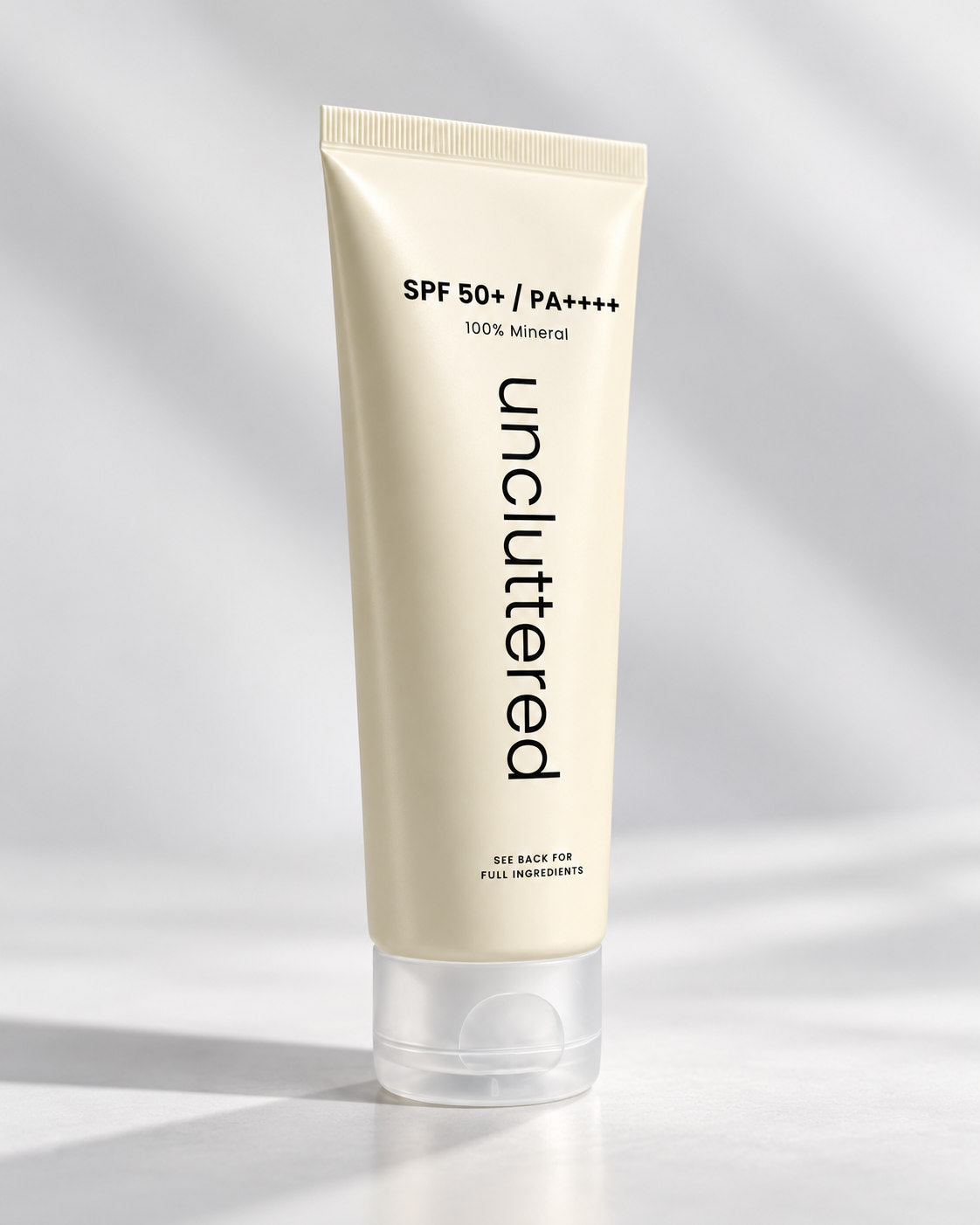 Uncluttered mineral sunscreen sealed tube three-quarter angled view on cool grey background